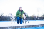 two adopted greyhounds on snow in the sunset